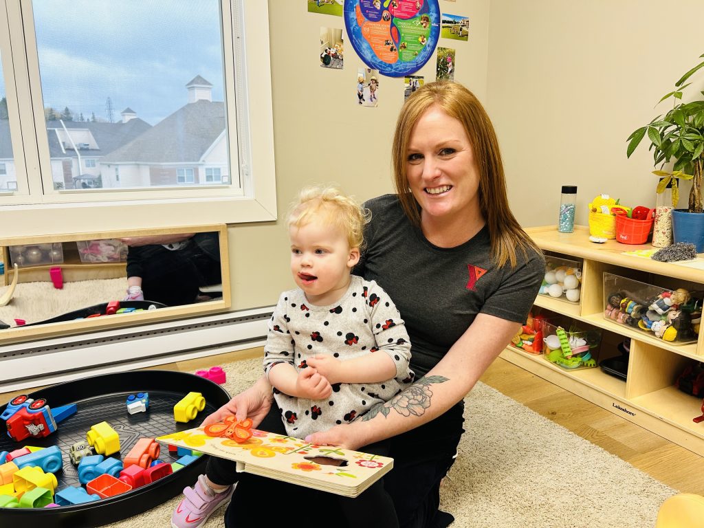 Early Childhood Educator Rachel McLaughlin holds child at a YMCA child care centre