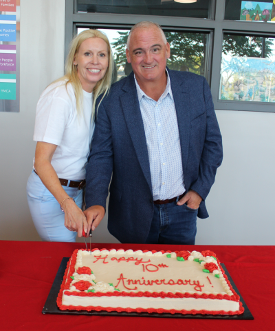 two people cutting a cake